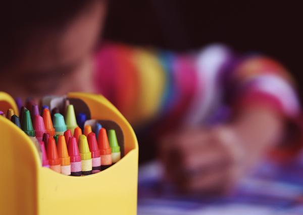 Child drawing with coloured pens